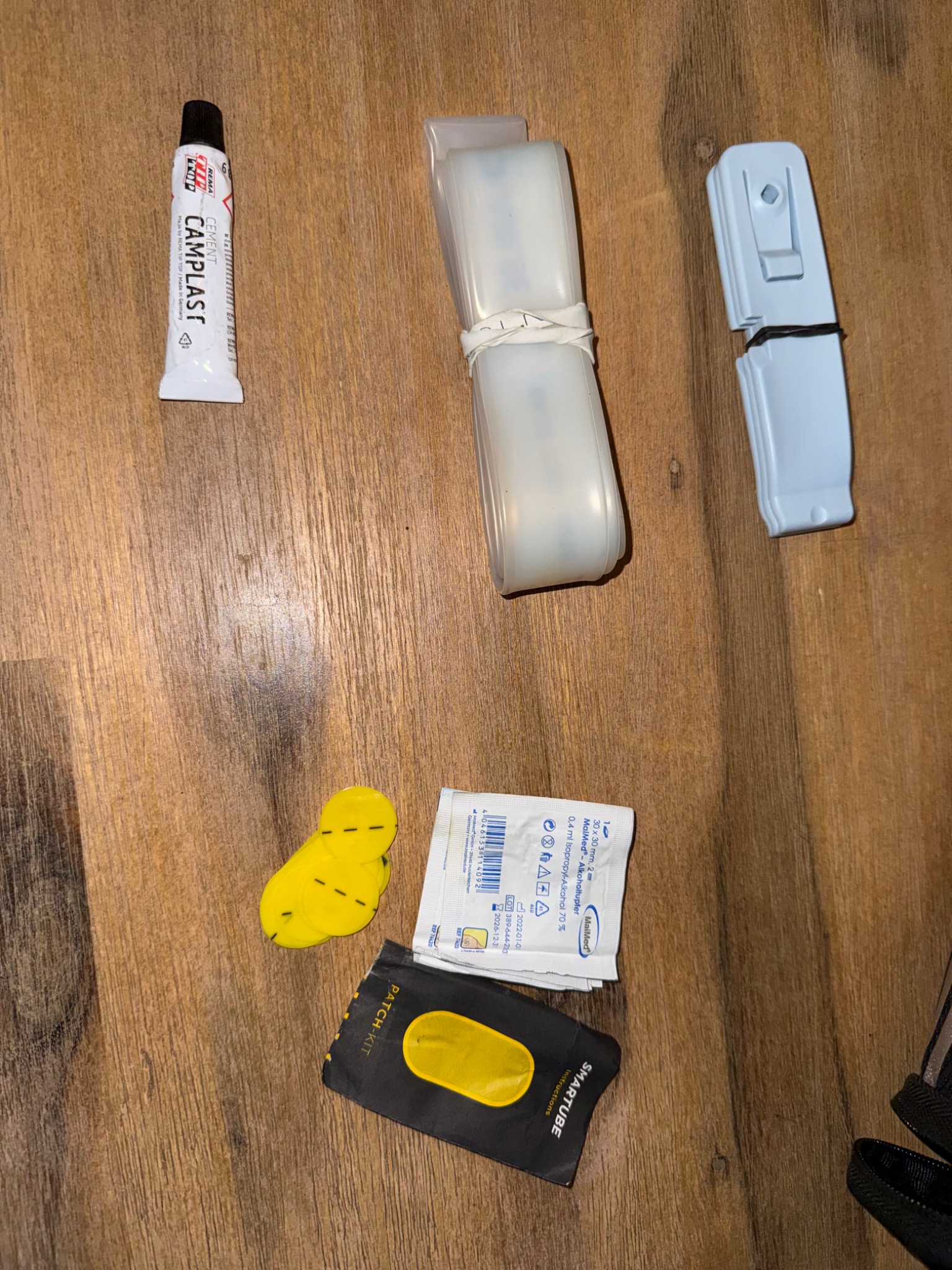Zusammengerollter transparenter Schwalbe-Aerothan-Ersatzschlauch neben Reifenhebern und Flickmaterial